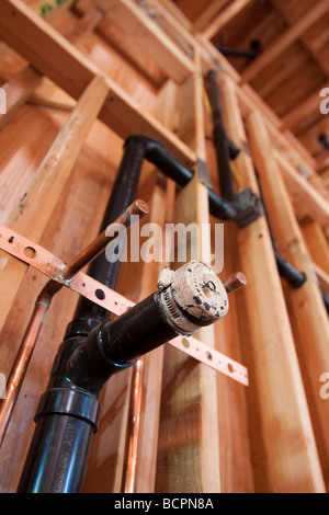 Les tuyaux de plomberie et des drains pour deux lavabos installés dans un mur à l'emplacement de la construction résidentielle Banque D'Images