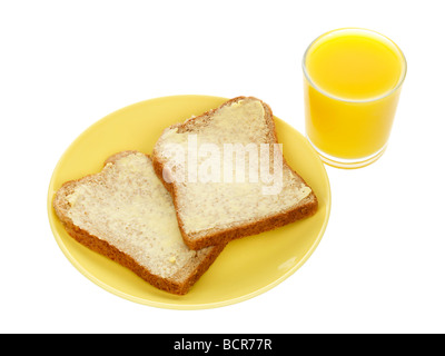 Le pain brun avec du beurre et du jus d'Orange Banque D'Images