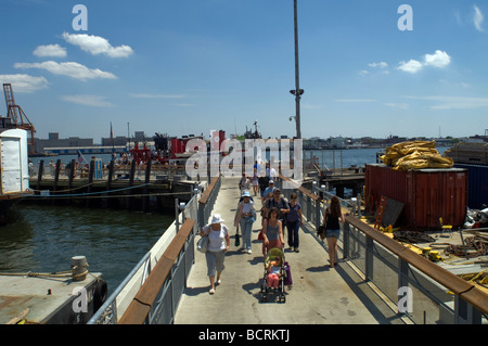 Les visiteurs de l'Île du gouverneur historique dans le port de New York à pied sur la jetée de Yankee Banque D'Images