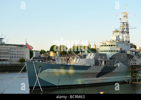 La proue de la Seconde Guerre mondiale croiseur HMS Belfast sur la Tamise avec de lourdes chaînes d'ancre et l'Union Jack Banque D'Images