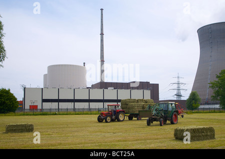 Le travail agricole à l'avant du hall de stockage du combustible nucléaire à la centrale nucléaire de Gundremmingen en Bavière, Allemagne. Banque D'Images