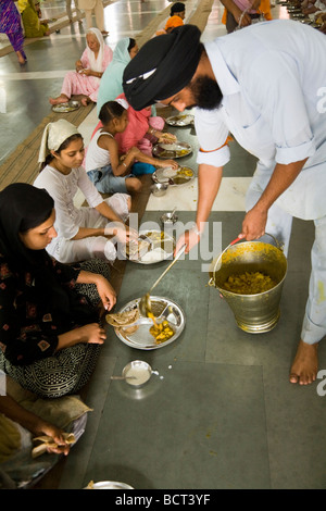 Homme Sikh servant de pèlerins au curry un repas gratuit à la cuisine communautaire, Golden Temple (Sri Harmandir Sahib) Amritsar. L'Inde. Banque D'Images