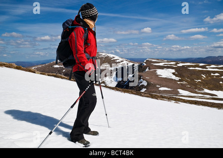 Female hiker prend compte tenu des Cairngorms de : Cairn Lochan sur journée de printemps, Cairgorms national park, Ecosse Banque D'Images