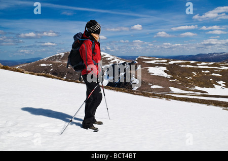 Female hiker prend compte tenu des Cairngorms de : Cairn Lochan sur journée de printemps, Cairgorms national park, Ecosse Banque D'Images