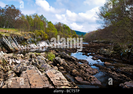 Le long de la rivière Carron des cailloux de la rivière pris le long de la route à voie unique entre Homestead et Amatnatua Sutherland en Écosse Banque D'Images