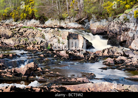 Le long de la rivière Carron des cailloux de la rivière pris le long de la route à voie unique entre Homestead et Amatnatua Sutherland en Écosse Banque D'Images