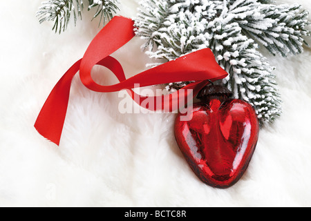 En forme de coeur rouge décoration de Noël sur couverture de branches de sapin avec fourrure Banque D'Images