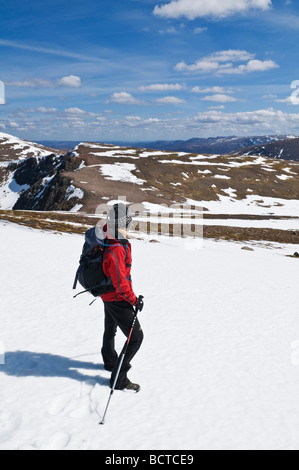 Female hiker prend compte tenu des Cairngorms de : Cairn Lochan sur journée de printemps, Cairgorms national park, Ecosse Banque D'Images