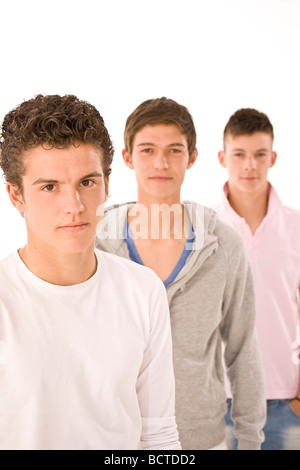 Trois garçons se tenant derrière eux Banque D'Images