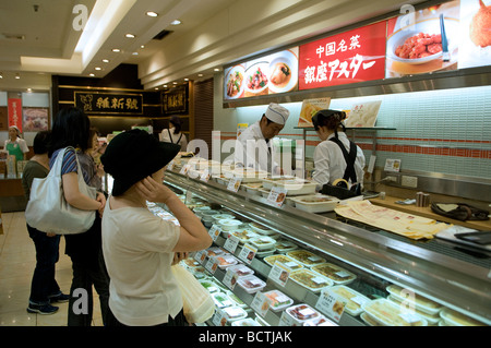 Les clients qui achètent de la nourriture à un comptoir lunch dans un centre commercial Tokyo Japon Banque D'Images