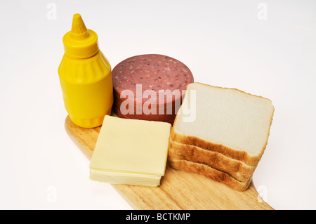 Ingrédients pour faire un salami et fromage charcuterie sandwich sur pain blanc avec de la moutarde Banque D'Images