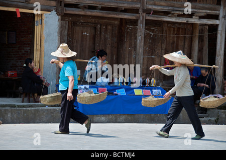 Deux femmes transportant du sable dans une méthode traditionnelle avec panier et pole Maan près de Guangxi Chine Sanjiang Banque D'Images