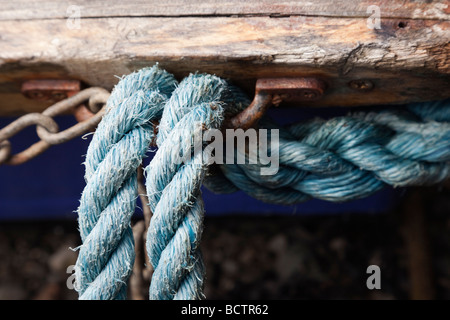 Close up of blue cordes attachées à un crochet en métal rouillé sur un vieux bateau Banque D'Images