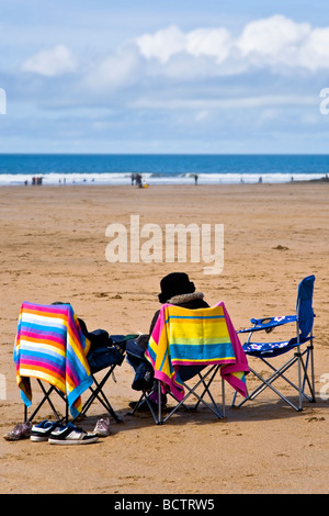 Personne âgée, assis sur chaise de camping, lecture, sur la plage Pavillon Bleu de Woolacombe Sands désignés dans le Nord du Devon Banque D'Images