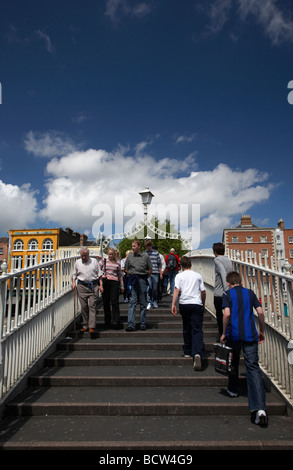 Les piétons qui traversent le halfpenny hapenny pont sur la rivière Liffey, dans le centre de la ville de Dublin République d'Irlande Banque D'Images