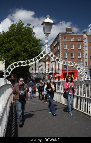 Les piétons qui traversent le halfpenny hapenny pont sur la rivière Liffey, dans le centre de la ville de Dublin République d'Irlande Banque D'Images