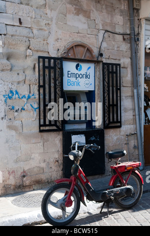 Un vieux scooter garé en face de la banque Emporiki cash machine dans la vieille ville, Chania, Crète Grèce. Banque D'Images