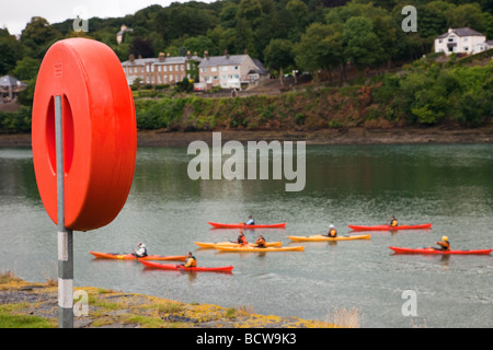 Menai Bridge Anglesey au nord du Pays de Galles UK bouée rouge à côté du détroit de Menai avec les gens sur l'eau en kayak Banque D'Images
