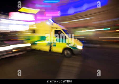 Une ambulance courses le long d'une rue de Londres la nuit. Banque D'Images