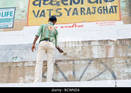 Jeune Indien homme travaillant sur une peinture murale lors de la préparation pour le festival du Diwali. Varanasi, Inde. Banque D'Images