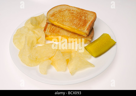 Sandwich au fromage sur pain blanc avec les chips de pomme de terre et cornichons sur fond blanc Banque D'Images