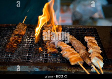 Brochettes de viande de poulet grillé yakitori par cuisson sur charbon de bois dans la rue Tokyo Japon Banque D'Images