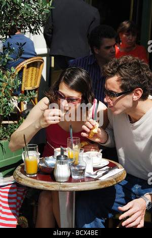 Couple ayant un snack au terrasse parisienne, Paris France Banque D'Images