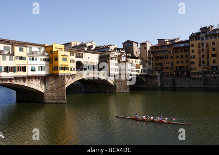 Les membres du club de l'Aviron Rowing Club train Florence sur l'Arno, Florence en passant sous l'Ponti Vecchio Banque D'Images