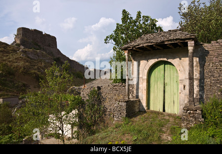 Entrée d'une maison en pierre de la période ottomane dans la vieille ville de Gjirokastra avec la citadelle en arrière-plan, le sud de l'Albanie Banque D'Images