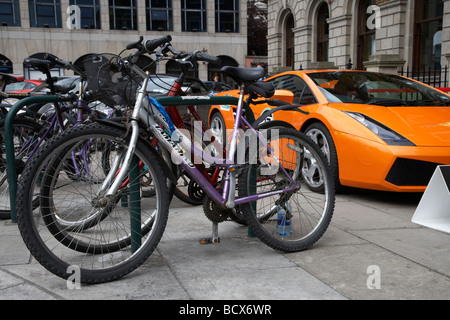 Voiture de sport lamborghini garée sur la chaussée à côté de la rangée de bicyclettes Dublin République d'Irlande illustrant écart de richesse et d'inégalité sociale Banque D'Images