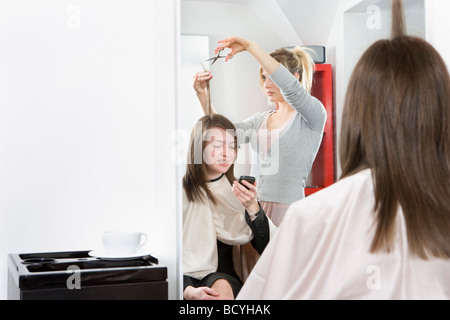 Femme parlant au téléphone à hairdressers Banque D'Images