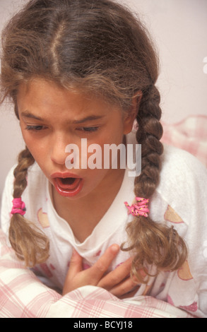 Jeune fille avec toux sèche au lit Banque D'Images