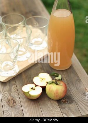 Les pommes, le jus de pomme et les verres sur la table Banque D'Images