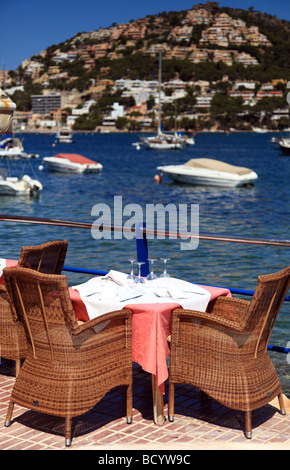 Un restaurant table à côté de la mer sur un mur du port Banque D'Images