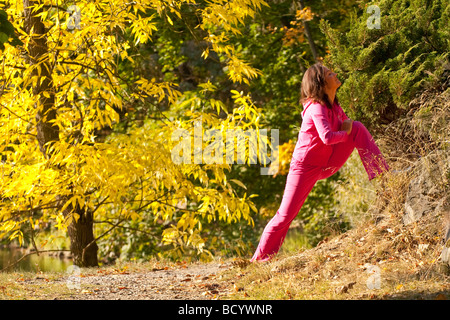 Woman stretching dans le parc Banque D'Images