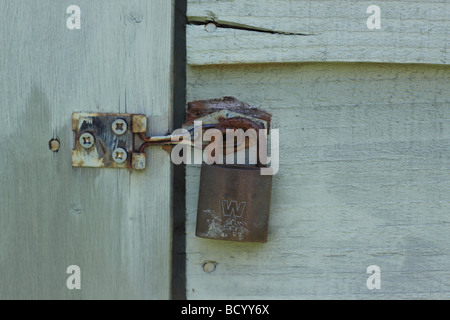 Et cadenas sur hasp peint en bleu abri de jardin en bois. Banque D'Images