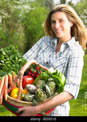 Femme tenant un panier de légumes Banque D'Images