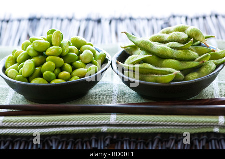 Les fèves de soja Edamame écossées et avec pods dans des bols Banque D'Images