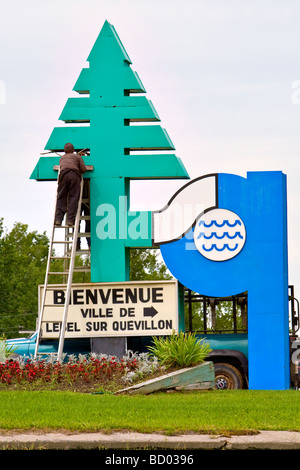 Les employés travaillent sur un panneau accueillant les voyageurs de la ville de Lebel-sur-Quévillon, Québec, Canada Banque D'Images