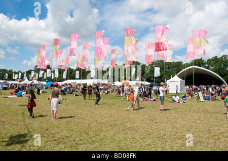 Les détenteurs de billets du festival marche à travers les drapeaux dans l'arène au festival de musique WOMAD 2009 Charlton Park Wiltshire UK Banque D'Images