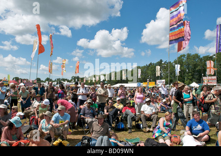 Les foules se rafraîchissent sur l'herbe au festival de musique WOMAD 2009 Charlton Park Wiltshire UK Banque D'Images