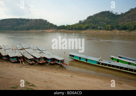 Lent en bois bateaux amarrés sur les rives du Mékong à Luang Prabang au Laos Banque D'Images