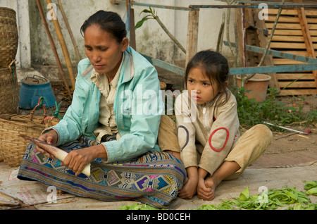 Une mère et sa fille sur le trottoir dans le marché alimentaire quotidienne de Luang Prabang au Laos Banque D'Images