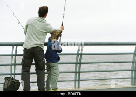 Père et fils de pêche pier, père fils aidant avec sa canne à pêche Banque D'Images