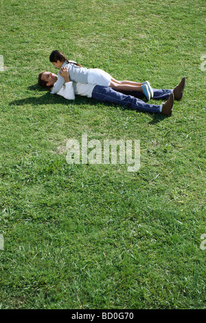 Père et fille lying together in grassy field Banque D'Images