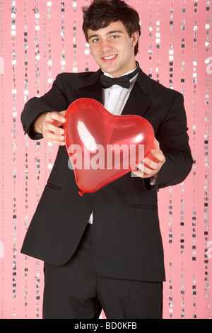 Young Man dressed in Suit Holding Heart Banque D'Images