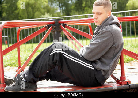 Young Man Sitting in Playground Banque D'Images