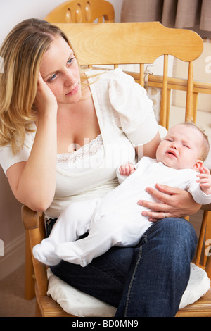 Inquiets Mother Holding Baby In Nursery Banque D'Images