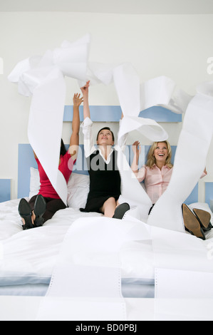 Trois collègues femmes throwing paper Banque D'Images