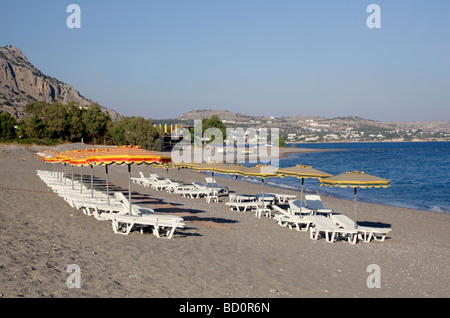 Transats et parasols sur la plage de sable près de Lothiarika Lardos Grèce Dodécanèse Rhodes Banque D'Images